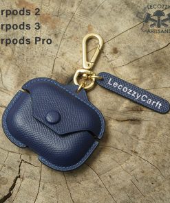 A custom leather cover designed to hold AirPods Pro wireless earbuds. The cover is made of tan and dark brown leather. It has a smooth, minimalist design that hugs the shape of the AirPods Pro case. The cover opens like a small book to allow access to insert and remove the earbuds. It provides protection while complementing the sleek aesthetic of the AirPods Pro.