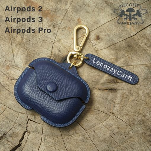 A custom leather cover designed to hold AirPods Pro wireless earbuds. The cover is made of tan and dark brown leather. It has a smooth, minimalist design that hugs the shape of the AirPods Pro case. The cover opens like a small book to allow access to insert and remove the earbuds. It provides protection while complementing the sleek aesthetic of the AirPods Pro.