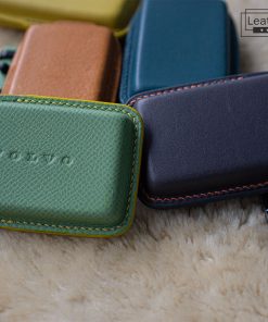 Close-up of several colorful leather key cases for Volvo EX30, EX40 and EX90 car keys. The cases are made of high-quality genuine leather and are available in a variety of colors with customizable stitching.