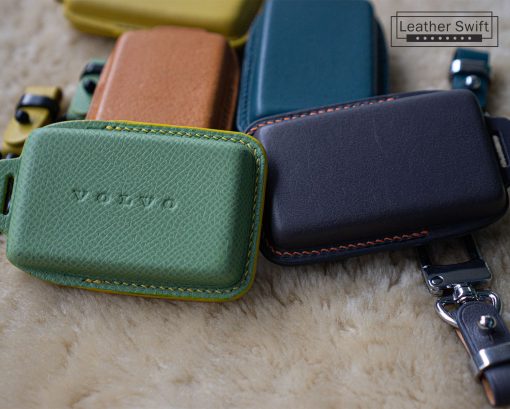 Close-up of several colorful leather key cases for Volvo EX30, EX40 and EX90 car keys. The cases are made of high-quality genuine leather and are available in a variety of colors with customizable stitching.