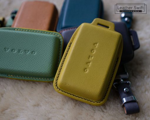 Close-up of several colorful leather key cases for Volvo EX30, EX40 and EX90 car keys. The cases are made of high-quality genuine leather and are available in a variety of colors with customizable stitching.